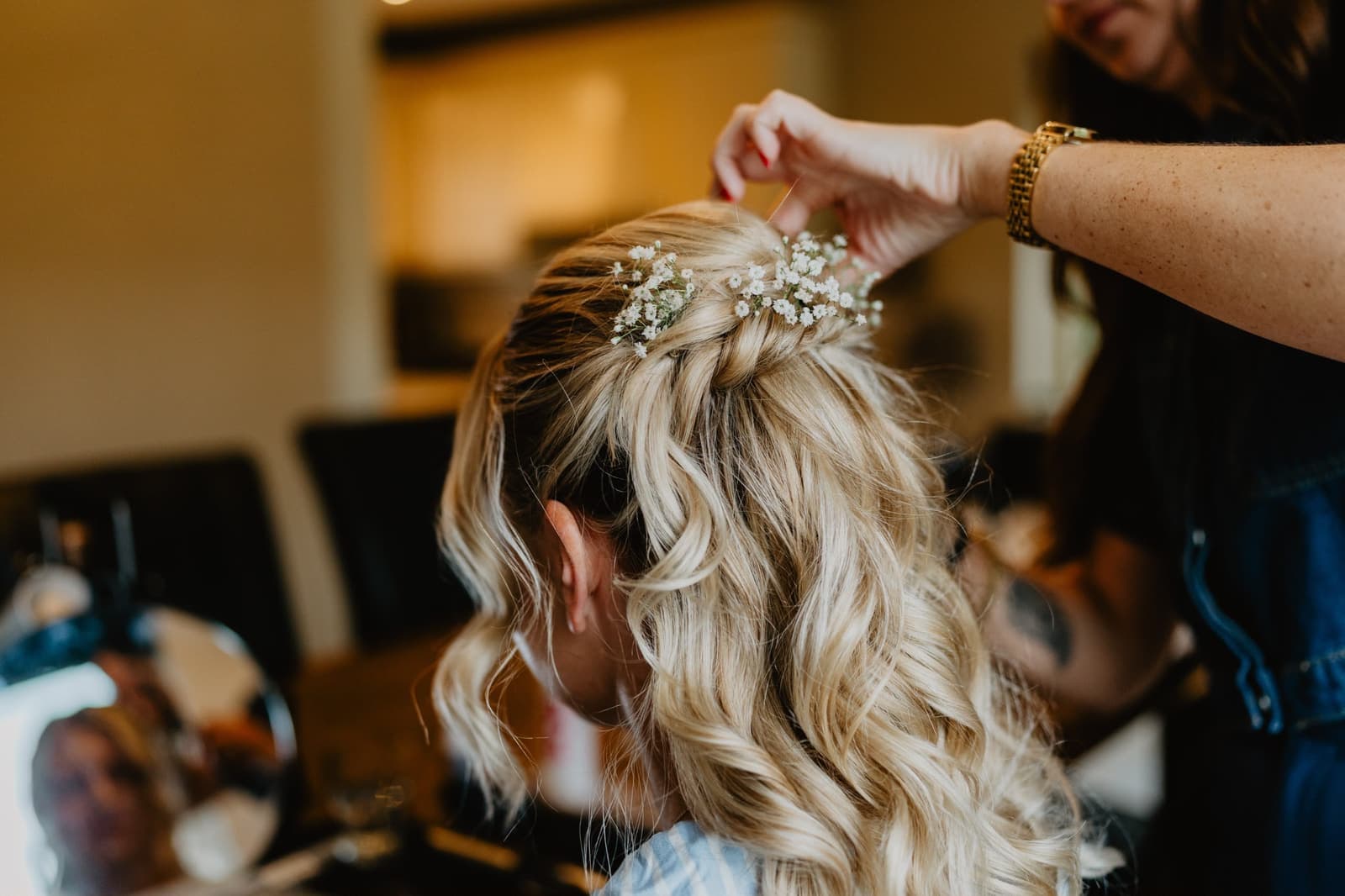 Bruidskapsel wordt afgewerkt met gipskruid in half opgestoken blond haar